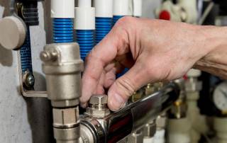 Eine Hand dreht an einem Ventil für Gas - Energiekosten