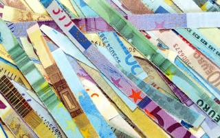 In Streifen geschnittene, bunte Geldscheine