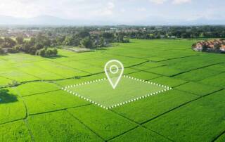 Luftaufnahme eines unbebauten, grünen Grundstücks mit markierter Fläche und Standort-Symbol, das die Entwicklungsmöglichkeiten und den gezielten Verkauf von Bauland veranschaulicht. | Grundstücksverkauf